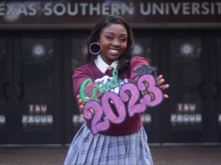 2019 Toyota Making Life Easier scholarship recipient Kennedy Beavers smiles and poses with a sign that says Grad 2023 in front of Texas Southern University. 